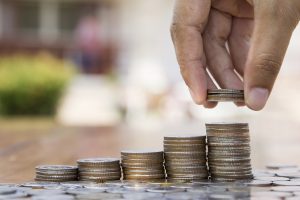 Saving and Business concept, hand putting coins to coin stack gr